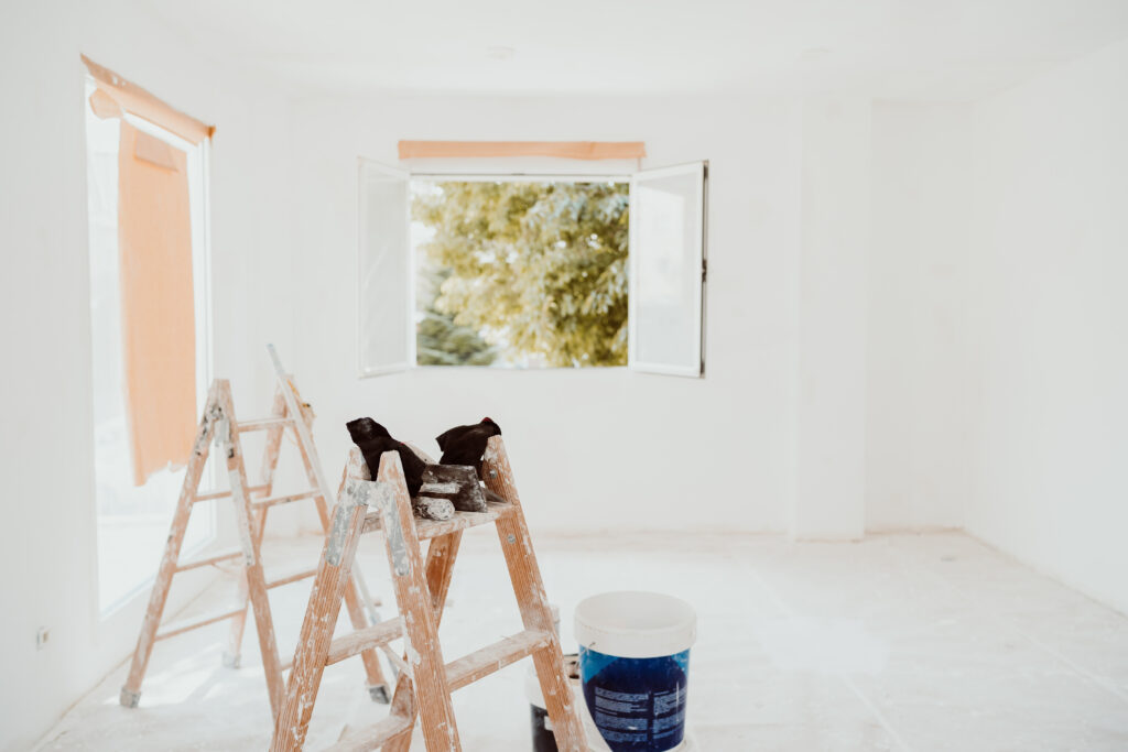 ladders and painter tools on white room at construction site. Pa