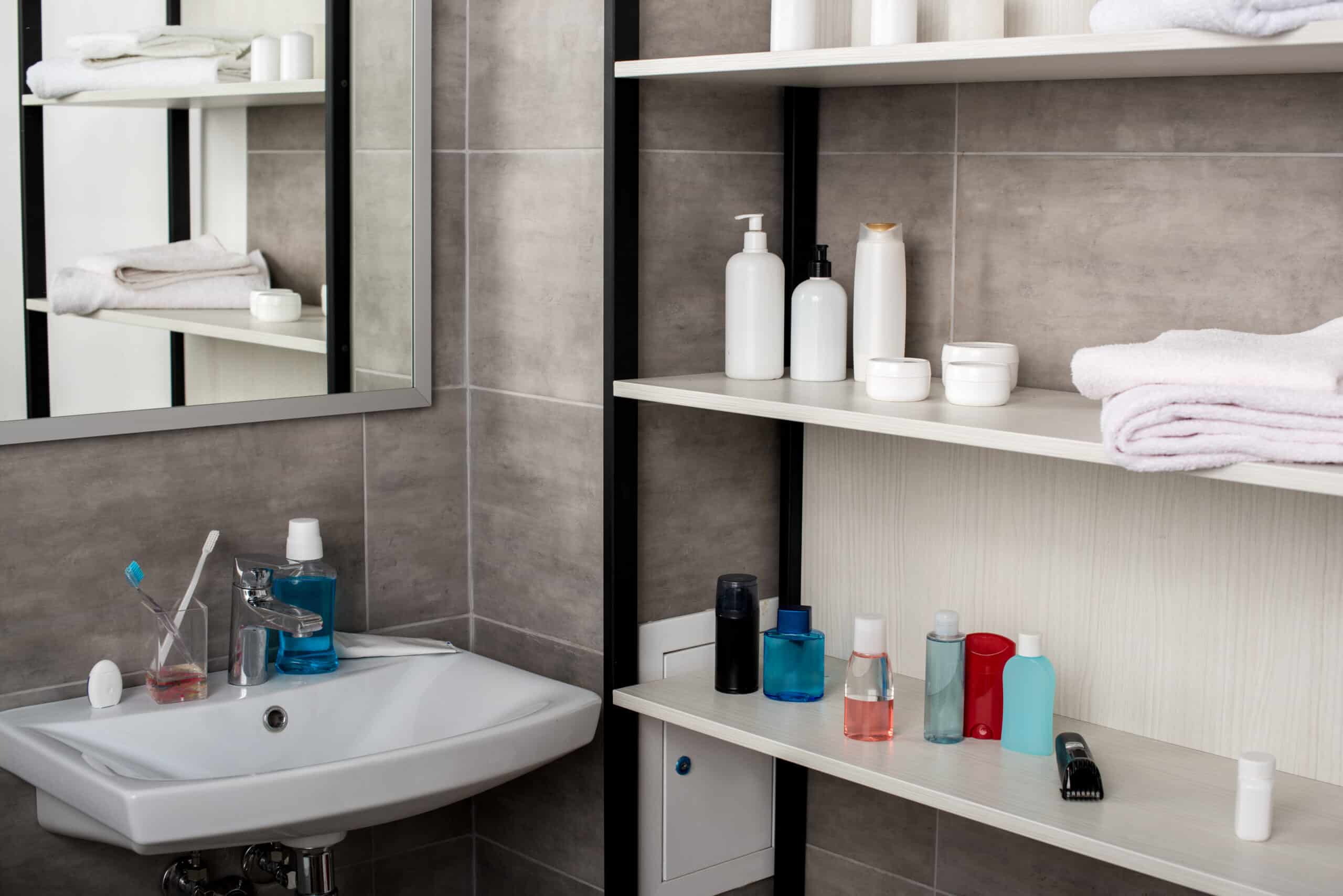 selective focus of modern bathroom with sinks and shelves with beauty products